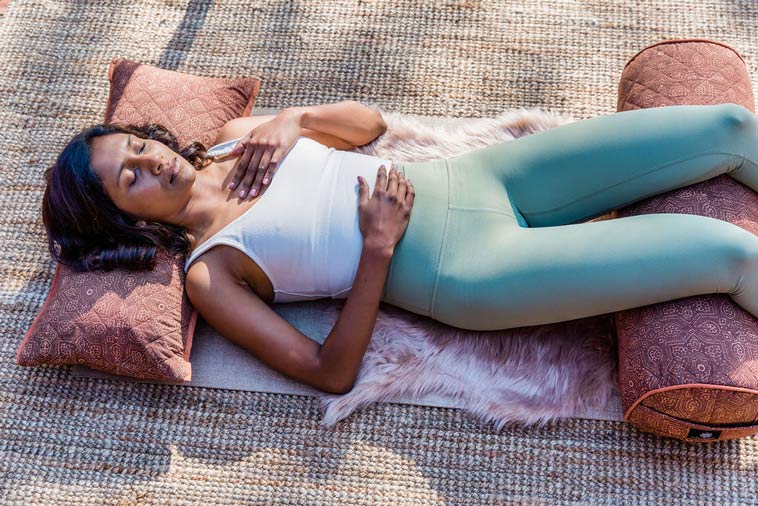 woman in a supported savasana for yoga nidra