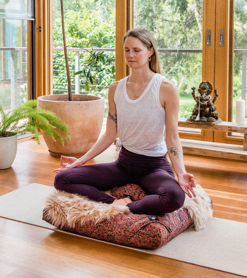 woman meditating on Calm Buddhi’s meditation comfort bundle